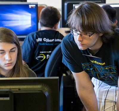 Zander Work (right) helps a student at the NW Cyber Camp held at Oregon State University.